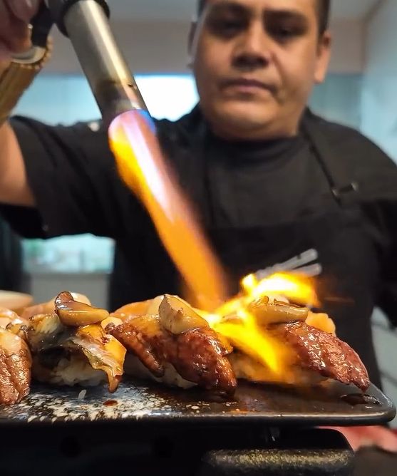 Chef flameando nigiri con soplete